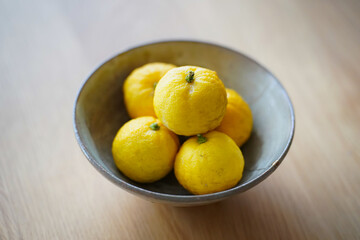 金継ぎされた陶器の器に盛られた旬を迎えて黄色く熟した柚子