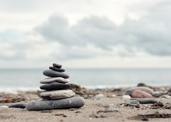 Fototapeta na wymiar Zen balancing stones on a cloudy beach