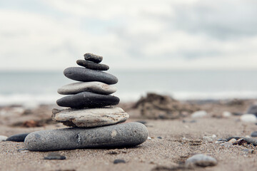 Fototapeta na wymiar Zen balancing stones on a cloudy beach