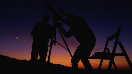 Men with astronomy telescope looking at the night sky, stars, planets, Moon and shooting stars.