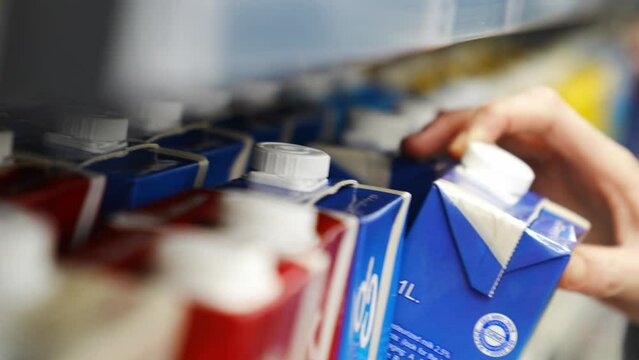 close-up. a woman chooses drinks on a shelf in a supermarket. 
