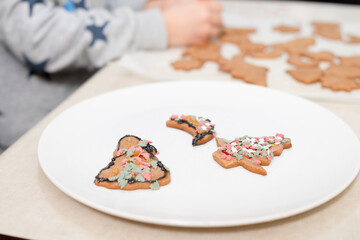 The boy's hands make Christmas cookies. The little cook.