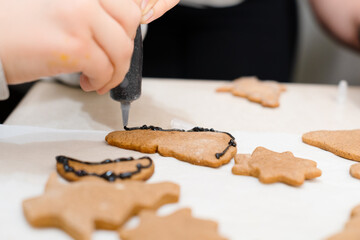 The boy's hands make Christmas cookies. The little cook.