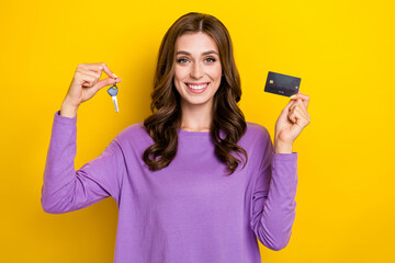 Photo of shiny cute girl dressed purple pullover holding credit card keys isolated yellow color background