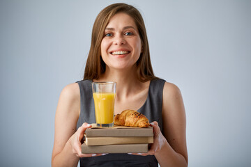 Smiling teacher or student holding lunch with juice and croissant on books. isolated advertising portrait.