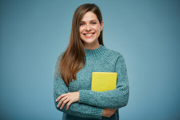 Smiling woman with crossed arms holding yellow book. Isolated advertising portrait.