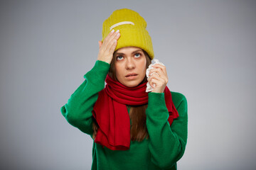 Sick woman in yellow hat touching her head with headache isolated portrait.