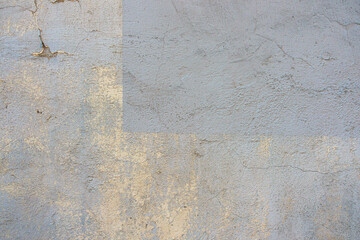 Grey concrete wall background texture. Old grunge uneven surface with scratches and cracks. Rough plaster cement gypsum wall outdoors