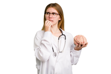 Young doctor caucasian woman holding a brain isolated relaxed thinking about something looking at a copy space.