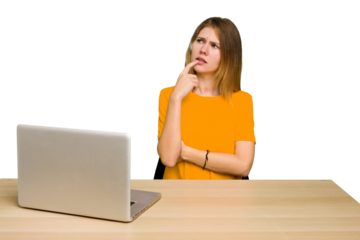 Young caucasian woman in a workplace working with a laptop isolated looking sideways with doubtful and skeptical expression.