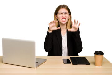Young business caucasian woman working on her workplace cutout isolated showing claws imitating a cat, aggressive gesture.