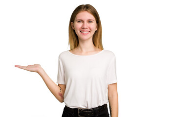 Young caucasian woman isolated showing a copy space on a palm and holding another hand on waist.