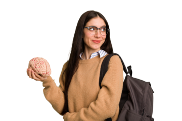 Young caucasian student woman holding a brain isolated looks aside smiling, cheerful and pleasant.