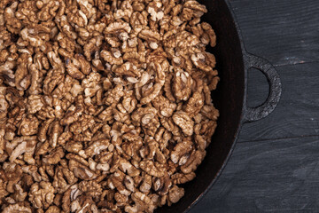 Walnut background. Peeled walnuts on a iron plate on black. walnuts a real super food full of vitamins and vegetable fats