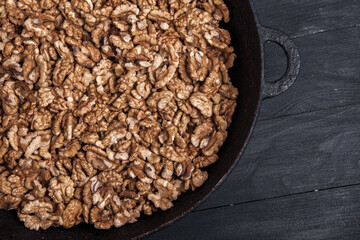 Walnut background. Peeled walnuts on a iron plate on black. walnuts a real super food full of vitamins and vegetable fats
