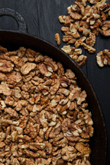 Walnut background. Peeled walnuts on a iron plate on black. walnuts a real super food full of vitamins and vegetable fats