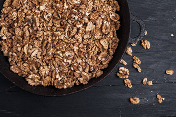 Walnut background. Peeled walnuts on a iron plate on black. walnuts a real super food full of vitamins and vegetable fats