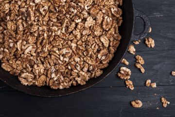 Walnut background. Peeled walnuts on a iron plate on black. walnuts a real super food full of vitamins and vegetable fats