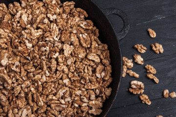 Walnut background. Peeled walnuts on a iron plate on black. walnuts a real super food full of vitamins and vegetable fats