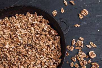 Walnut background. Peeled walnuts on a iron plate on black. walnuts a real super food full of vitamins and vegetable fats