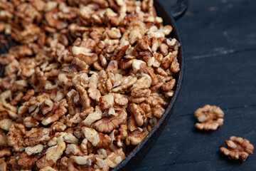 Walnut background. Peeled walnuts on a iron plate on black. walnuts a real super food full of vitamins and vegetable fats