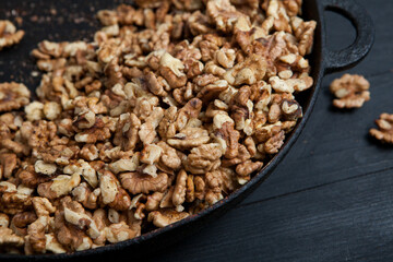 Walnut background. Peeled walnuts on a iron plate on black. walnuts a real super food full of vitamins and vegetable fats