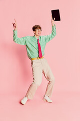 Funny emotional man, student geek wearing vintage style shirt and trousers having fun, using tablet...