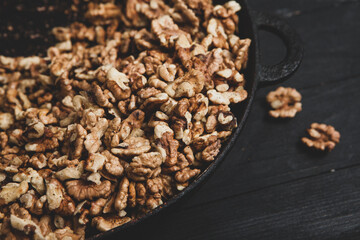 Walnut background. Peeled walnuts on a iron plate on black. walnuts a real super food full of vitamins and vegetable fats