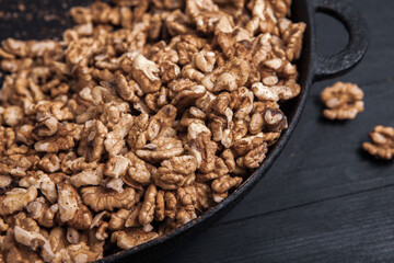 Walnut background. Peeled walnuts on a iron plate on black. walnuts a real super food full of vitamins and vegetable fats