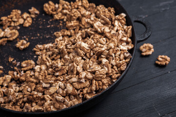Walnut background. Peeled walnuts on a iron plate on black. walnuts a real super food full of vitamins and vegetable fats
