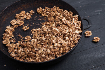 Walnut background. Peeled walnuts on a iron plate on black. walnuts a real super food full of vitamins and vegetable fats