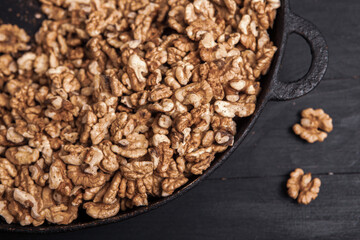 Walnut background. Peeled walnuts on a iron plate on black. walnuts a real super food full of vitamins and vegetable fats
