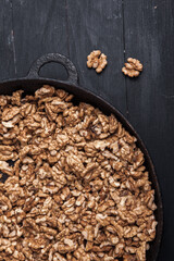 Walnut background. Peeled walnuts on a iron plate on black. walnuts a real super food full of vitamins and vegetable fats