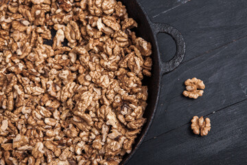 Walnut background. Peeled walnuts on a iron plate on black. walnuts a real super food full of vitamins and vegetable fats