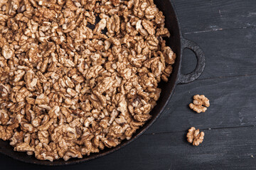 Walnut background. Peeled walnuts on a iron plate on black. walnuts a real super food full of vitamins and vegetable fats