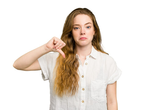 Young caucasian redhead woman isolated showing a dislike gesture, thumbs down. Disagreement concept.