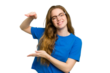 Young caucasian redhead woman isolated holding something little with forefingers, smiling and confident.