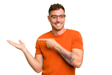 Young caucasian handsome man isolated excited holding a copy space on palm.