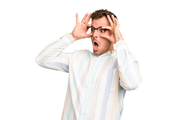 Naklejka premium Young caucasian handsome man isolated keeping eyes opened to find a success opportunity.