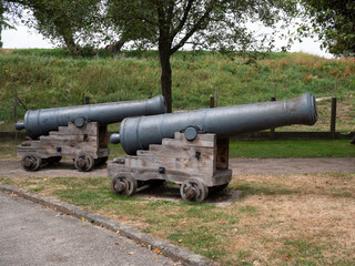 Heavy old naval guns on a wooden base called a carriage
