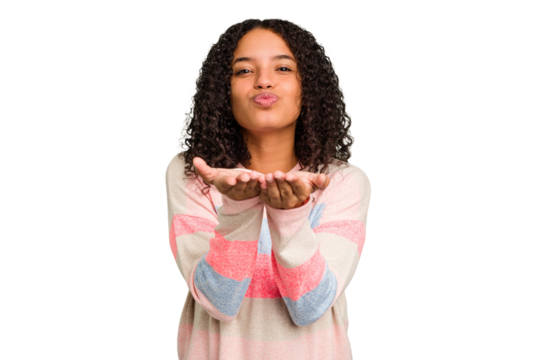Young Brazilian curly hair cute woman isolated folding lips and holding palms to send air kiss.