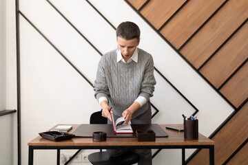 woman accountant with a short haircut in a stylish office at her desk sorts out documents