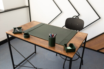 clean tidy workplace in the office with a green writing pad and stationery