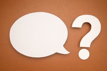 White speech bubble and a white question mark on a brown background