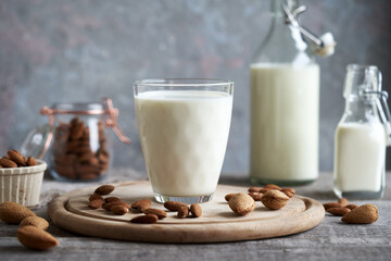 A гласс of vegan almond milk with whole and shelled almonds