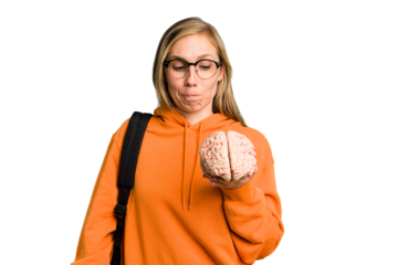 Young student caucasian woman holding a brain isolated confused, feels doubtful and unsure.
