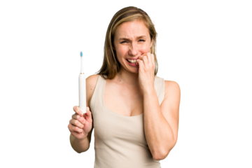 Young caucasian holding a brushing teeth isolated biting fingernails, nervous and very anxious.