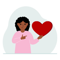 A girl holds a big red heart in his hand. The concept of volunteering, romantic relationship or love.
