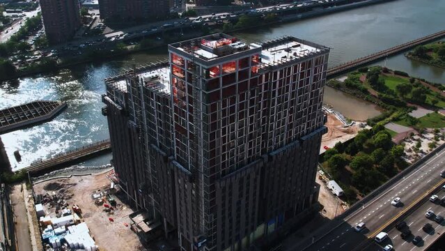 Aerial view away from a building under construction in Bronx, NY, USA - reverse, tilt, drone shot