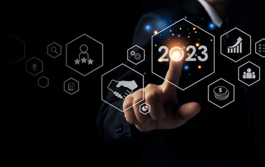 Businessman pointing to 2023 with business plan and strategy icon for achieving goals, Start up...